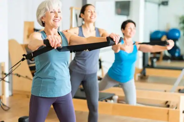 Toning Arms After 60: Empowering Womens Fitness Through Effective Weight Training 2 older woman doing weight training Purfleet and resistance in the gym to tone upper arms