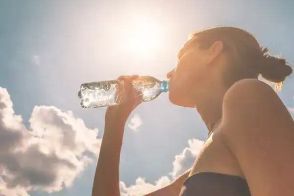 Hydration: The Secret Ingredient for a Toned Stomach and Enhanced Fitness 3 Image of woman drinking water to hydrate Purfleet after run.