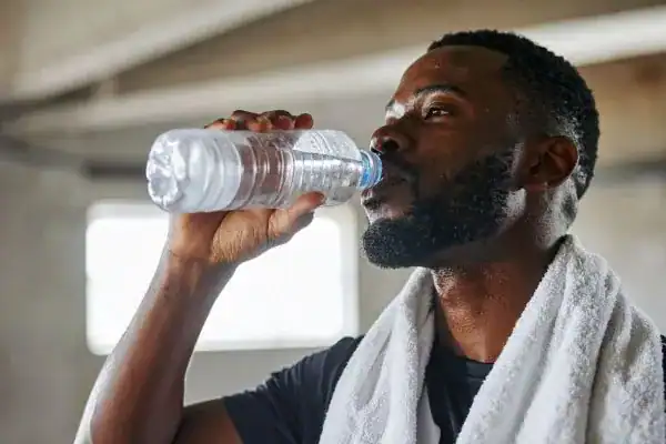 Hydration: The Secret Ingredient for a Toned Stomach and Enhanced Fitness 1 Image of man drinking water to improve hydration Purfleet after work out.